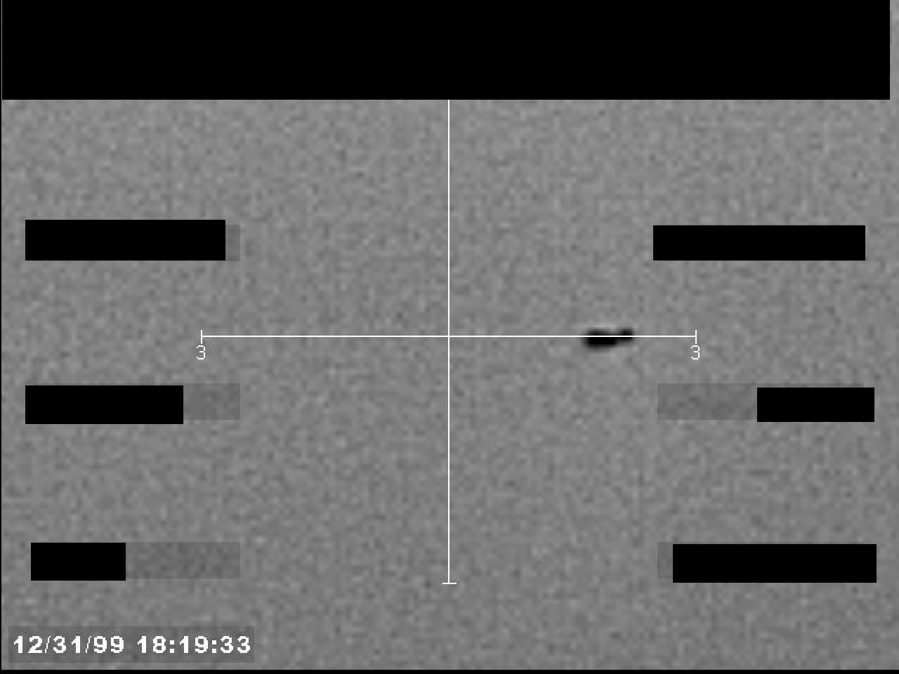 Embedded image object from the official FBI Photo B23 PDF: redacted grayscale still frame with central reticle and compact unresolved dark feature